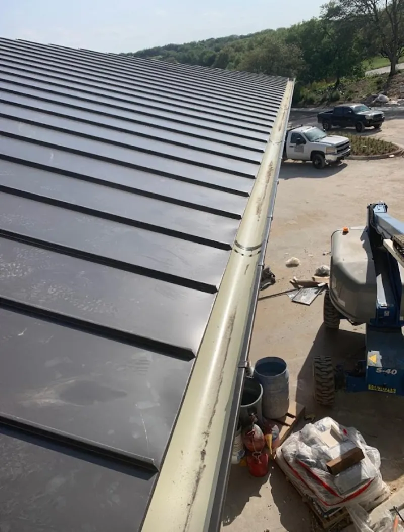 Standing seam panel and gutter detail on a metal roofing jobsite in Williamson